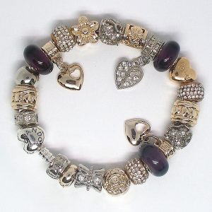 Purple charm bracelet with deep purple, gold, silver, heart clip, Murano glass, pavé crystal, floral details, and European-style charms on an authentic Pandora bracelet