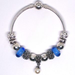 925 sterling silver bangle bracelet with blue, silver, faux pearl dangle, heart clips, Murano glass, floral details, and European-style charms on an authentic Pandora bangle