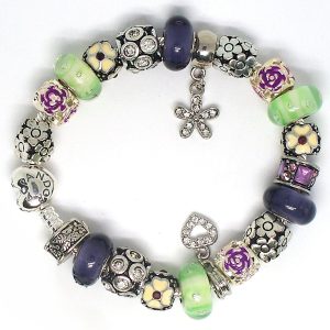 70s charm bracelet with purple, green, silver, floral clip, flower dangle, heart dangle, Murano glass beads, and European charms on an authentic Pandora bracelet