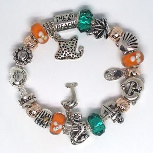 Beach themed charm bracelet with aqua, teal, orange, gold, rose gold, silver, Murano glass, faceted beads, and European charms on an authentic Pandora bracelet
