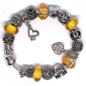 Yellow charm bracelet with yellow, silver, flower, mom, love, Murano glass, faceted glass, and European-style charms on an authentic Pandora bracelet