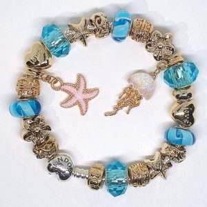 Gold tone charm bracelet with pink, blue, white, gold, silver, starfish, Murano glass, and European-style beach charms on an authentic Pandora bracelet
