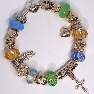 Boho charm bracelet with blue, green, yellow, gold, silver, floral, feather, cross, heart, Murano glass, and European-style charms on an authentic Pandora bracelet
