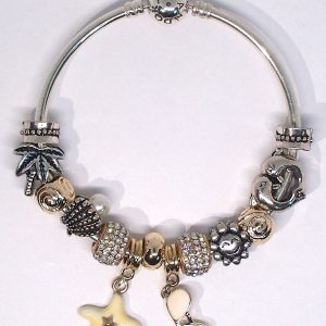Sterling silver beach charm bracelet with gold, silver, ivory, red, and coastal European-style charms